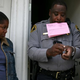 An evicted renter (left) looks on as Alameda County Sheriff Deputy Ken Cammack prepares to post a notice of eviction on the door of an apartment where tenants defaulted on rent payments June 4, 2009, in Oakland, Calif.
Justin Sullivan/Getty Images
